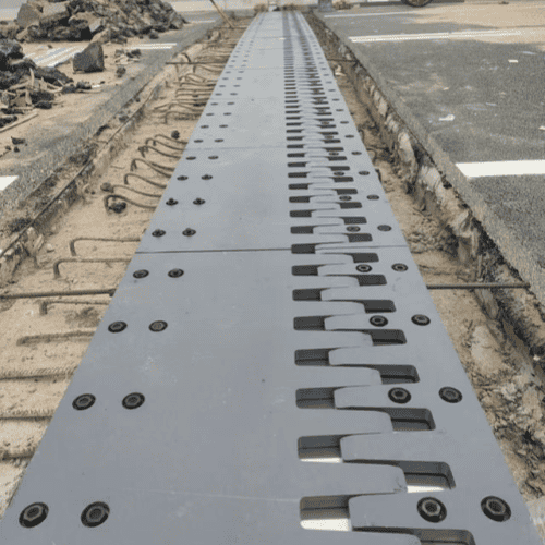 Finger plate expansion joint installation – steel finger plates being placed into bridge deck gap and secured with anchor bolts